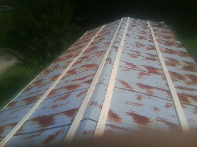 Rusted metal roof panels with new wood purlins before replacement — Storm Damage Roof Repair in Mineola by Roofing Brothers